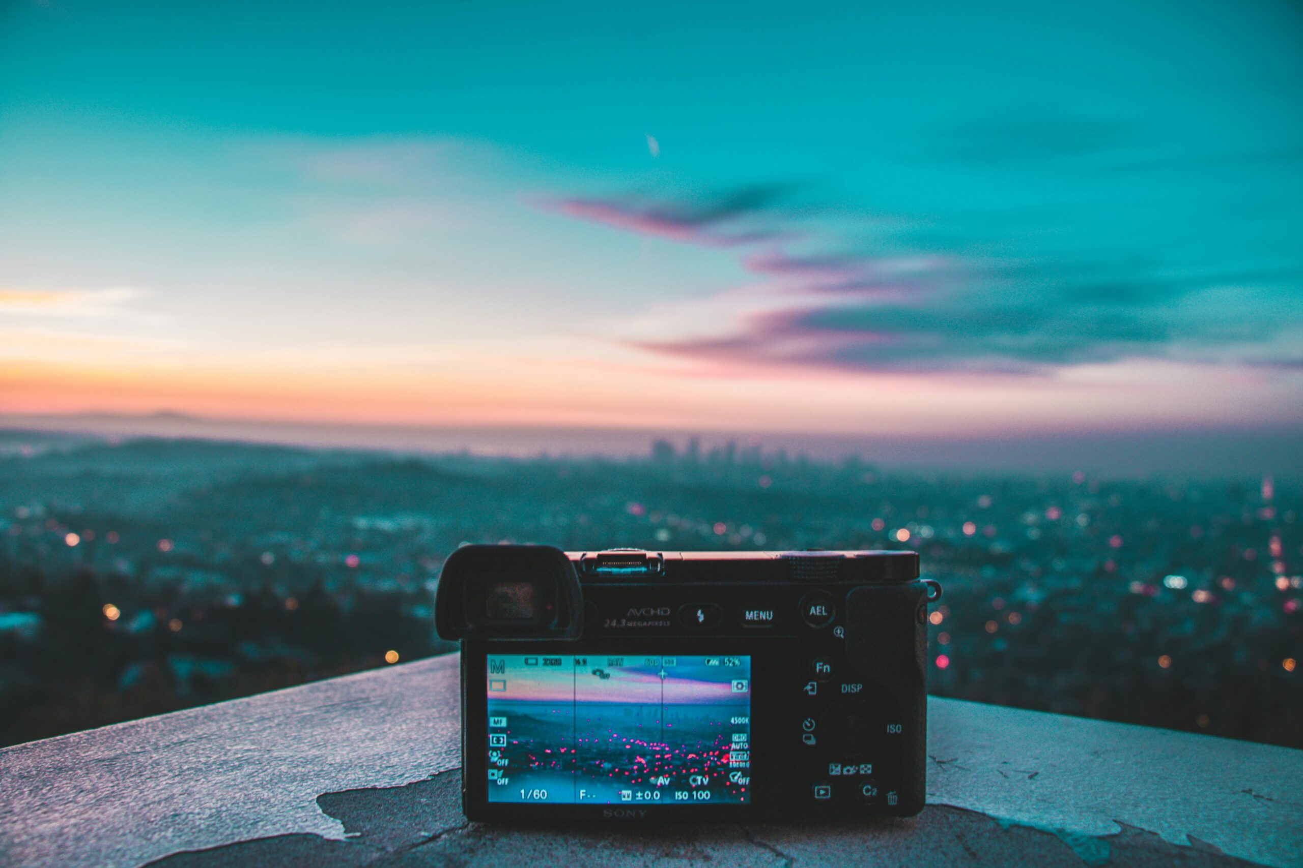 Home Camera capturing a stunning cityscape and colorful sunset from a high vantage point.